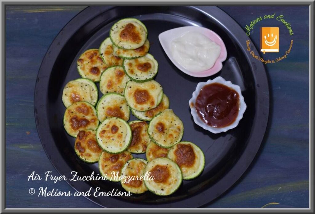Air Fryer Zucchini Mozzarella served on a black plate along with dips; top view