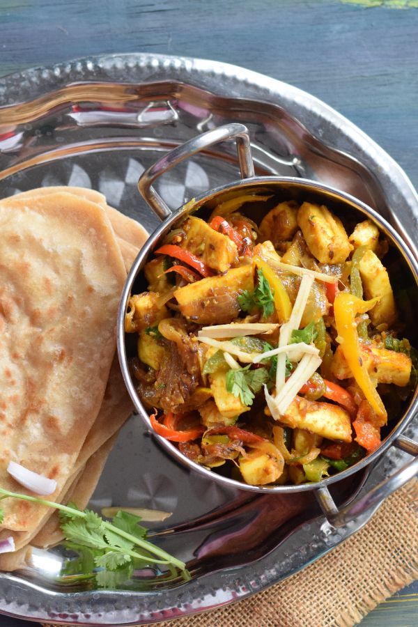 paneer jalfrezi in a small wok along with paratha