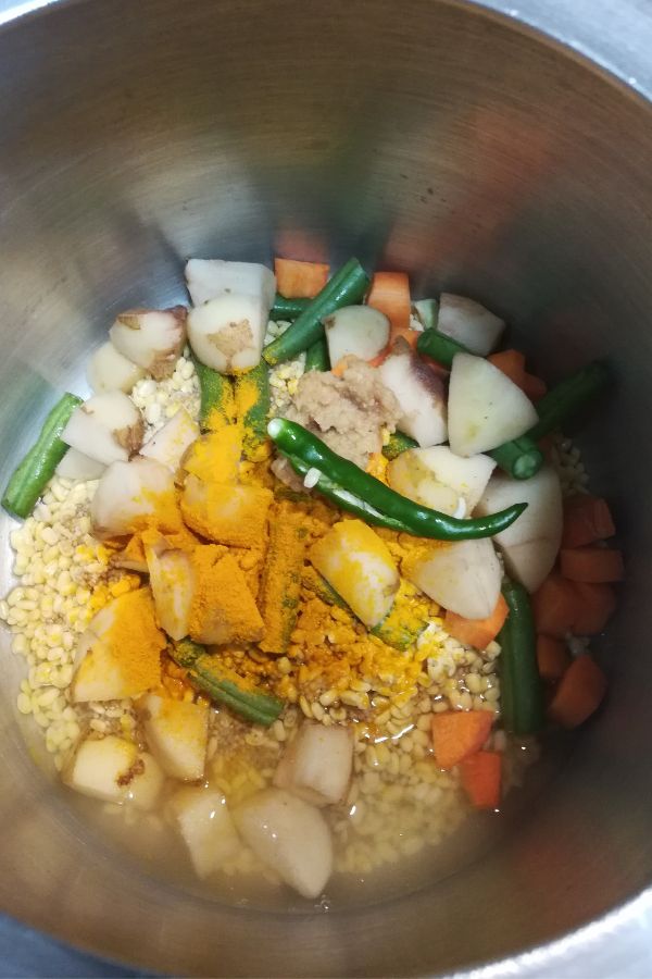 Millet, dal, vegetables in pressure cooker along with spices