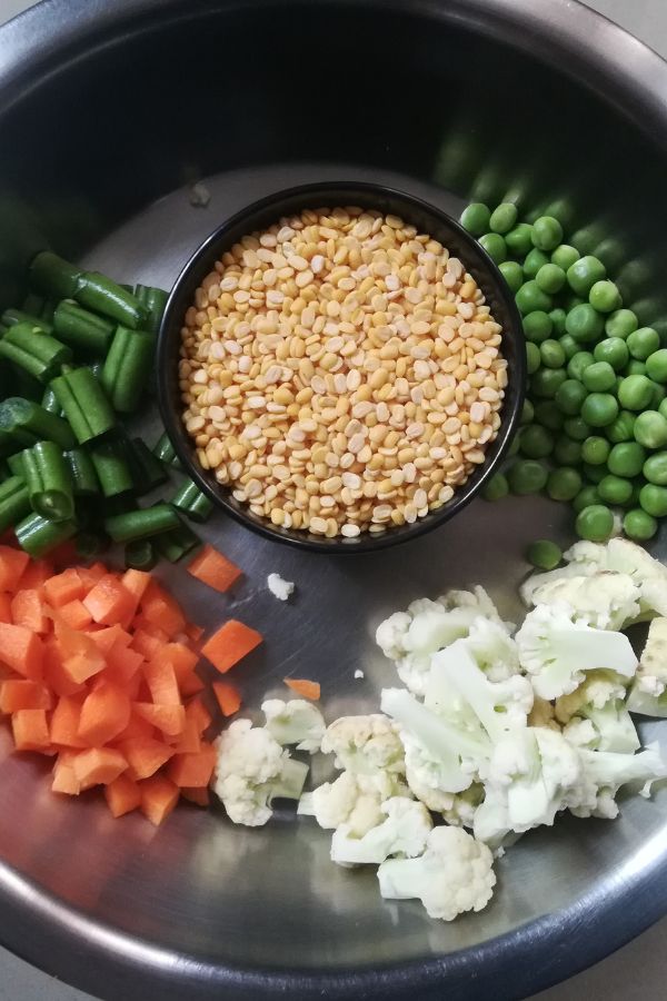chopped vegetables in a plate and dal in a bowl