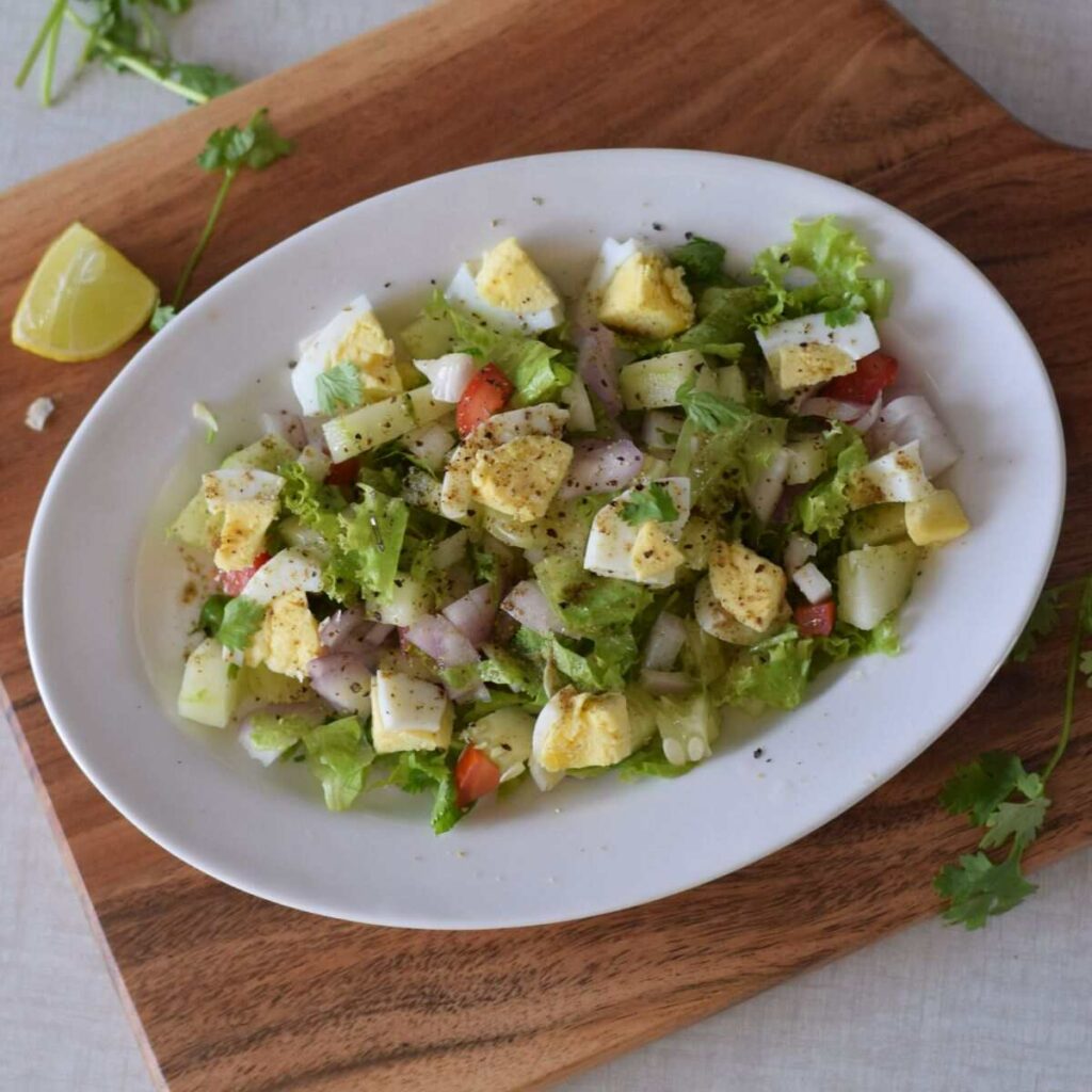 A plateful of egg salad kept on wooden board
