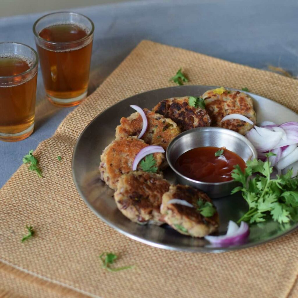 rajma tikkis served in a steel plate along with ketchup and black tea