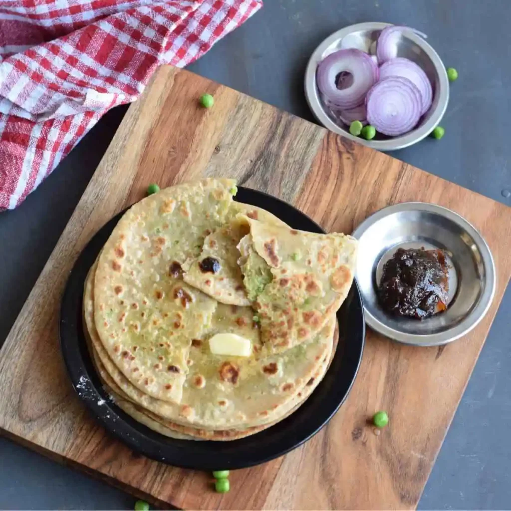 torn peas paratha along with pickle and onion