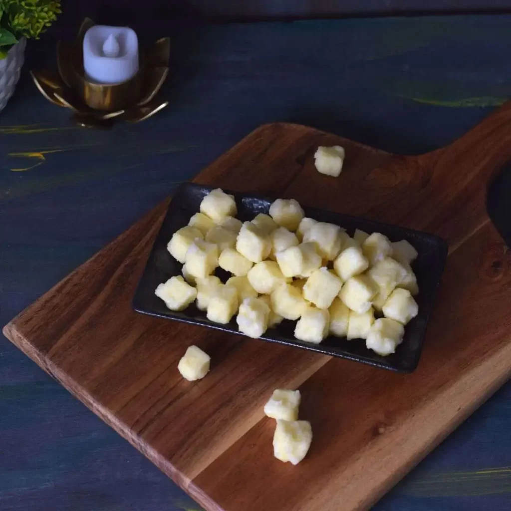 chena murki on a black rectangular plate kept on wooden board and candle on the background