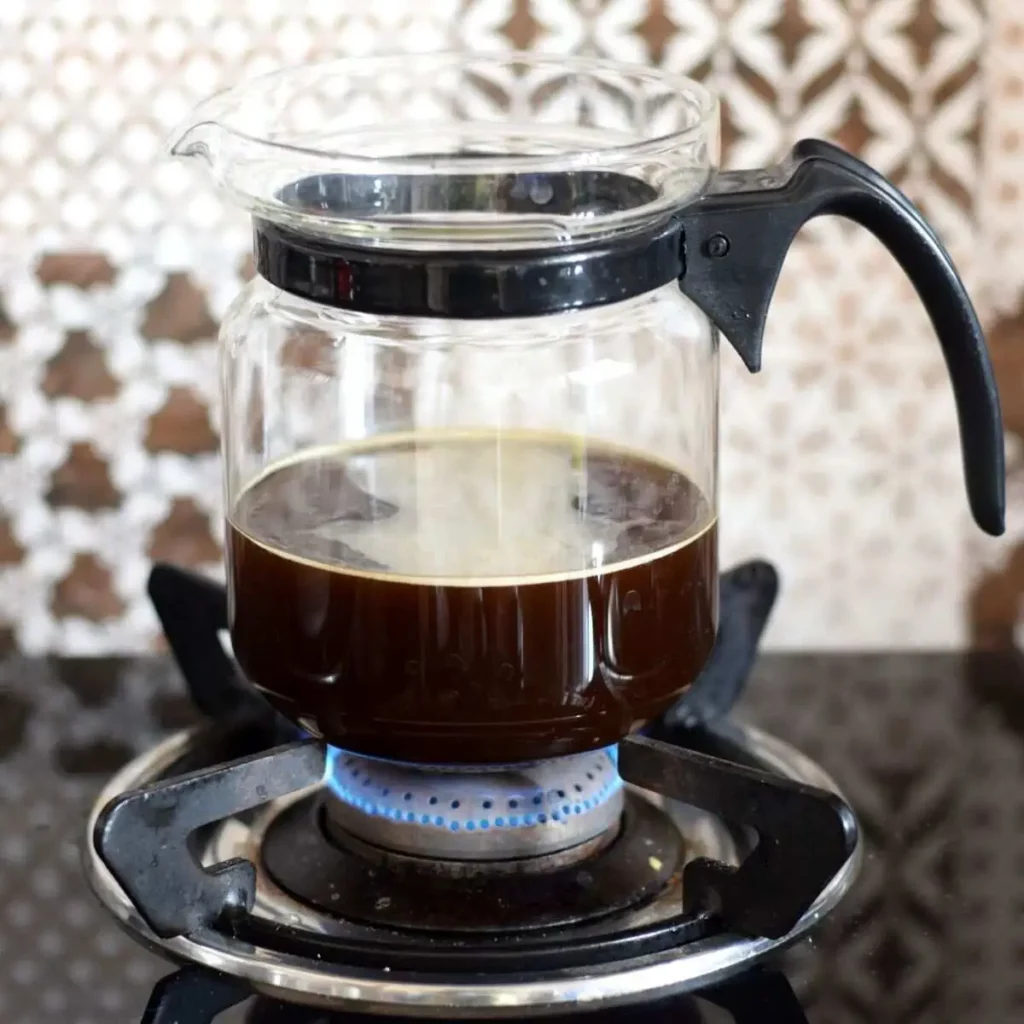 Brewing coffee in a glass kettle on stovetop