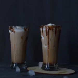 Cold coffee in two tall glasses and some ice cubes