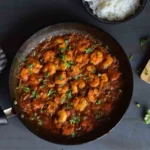 prawn bhuna in a non stick pan along with white rice; top view