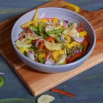 bell pepper cucumber salad in a bowl kept on a wooden board